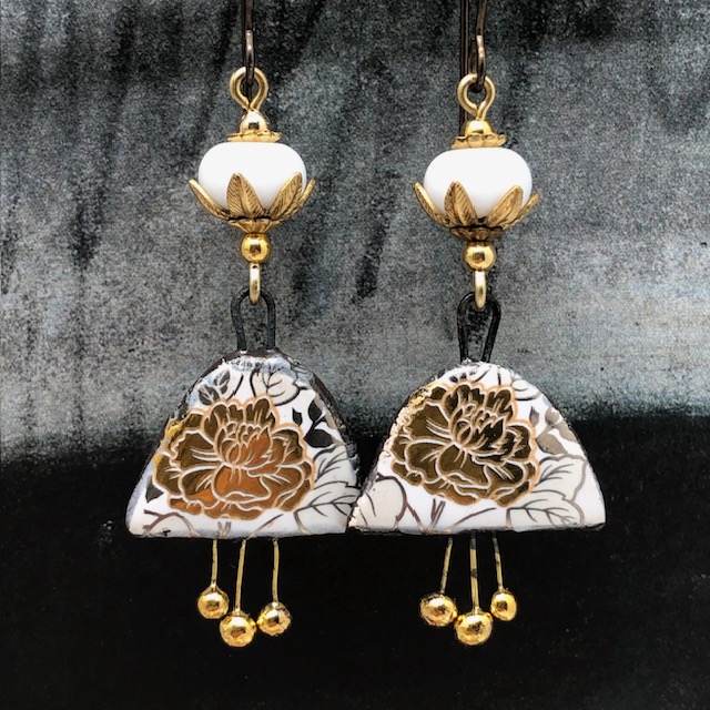 Boucles d'oreilles bohèmes composées de pendentifs en céramique avec un motif de fleurs dorées au feuillage argenté. Bijoux uniques de créateur.