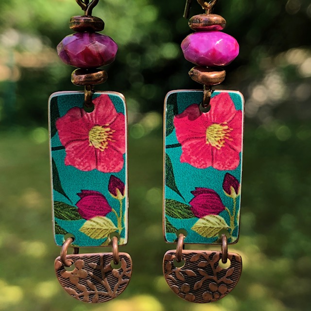 Boucles d’oreilles composées de pendentifs artisanaux en cuivre illustré et de perles en rhodonite rose. Crochets d’oreilles en laiton. Pièces uniques.