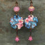 Boucles d’oreilles poétiques composées de pendentifs artisanaux en cuivre émaillé représentant des fleurs rose et bleu. Bijoux uniques de créateur.