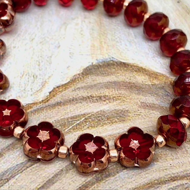 Bracelet élastique bohème chic rouge carmin composé de perles en verre de Bohême rondes et de perles en forme de fleur. Bracelet stretch de créateur.