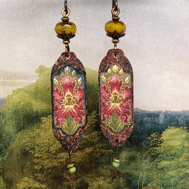 Boucles d'oreilles bohèmes composées de pendentifs en cuivre émaillé représentant des fleurs sauvages rouge et jaune sur un fond vert. Pièces uniques.
