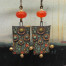 Grandes boucles d'oreilles bohèmes composées de pendentifs en céramique avec des fleurs vert kaki et orange vif. Bijoux uniques de créateur.
