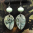 Boucles d’oreilles asymétriques vert forêt composées de pendentifs en céramique avec une forme de feuille d'arbre. Bijoux uniques de créateur.