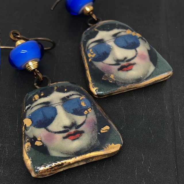 Boucles d'oreilles en céramique représentant Lina Cavalieri, dessinée par Fornasetti, avec les moustaches de Dali et une paire de lunettes bleu.