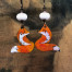 Boucles d’oreilles asymétriques composées de pendentifs en cuivre émaillé représentant un renard roux et blanc. Bijoux uniques de créateur.