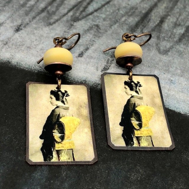 Boucles d'oreilles bohèmes composées de pendentifs artisanaux en cuivre illustré représentant une geisha. Bijoux uniques de créateur.