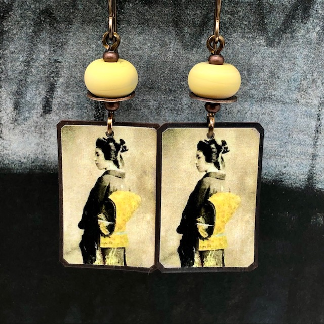 Boucles d'oreilles bohèmes composées de pendentifs artisanaux en cuivre illustré représentant une geisha. Bijoux uniques de créateur.