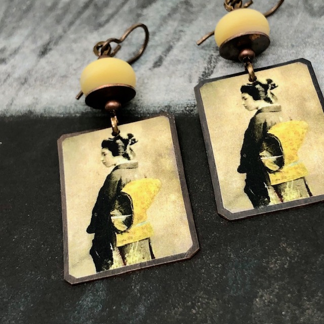 Boucles d'oreilles bohèmes composées de pendentifs artisanaux en cuivre illustré représentant une geisha. Bijoux uniques de créateur.
