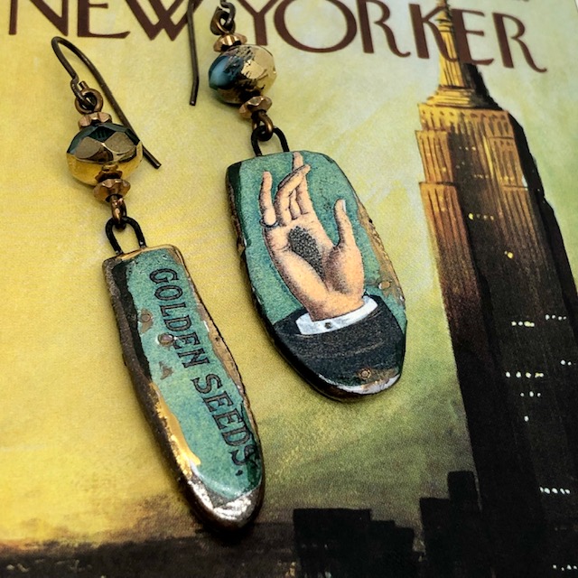 Boucles d'oreilles bohème composées de pendentifs en céramique turquoise et or avec une inscription et une main. Pièces uniques.