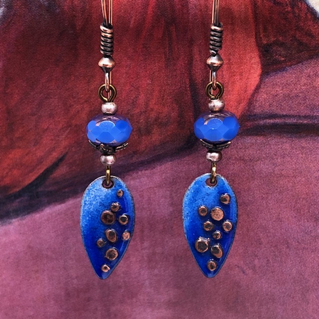 Boucles d'oreilles bohème composées de pendentifs artisanaux en cuivre émaillé bleu Klein en forme de feuilles. Pièces uniques.