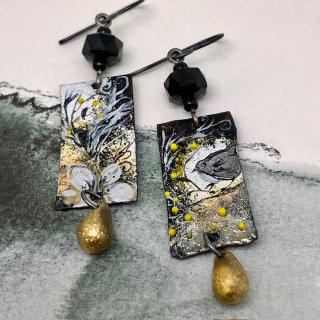 Boucles d’oreilles asymétriques et poétiques composées de pendentifs en cuivre émaillé représentant des oiseaux et une fleur. Bijoux uniques de créateur.
