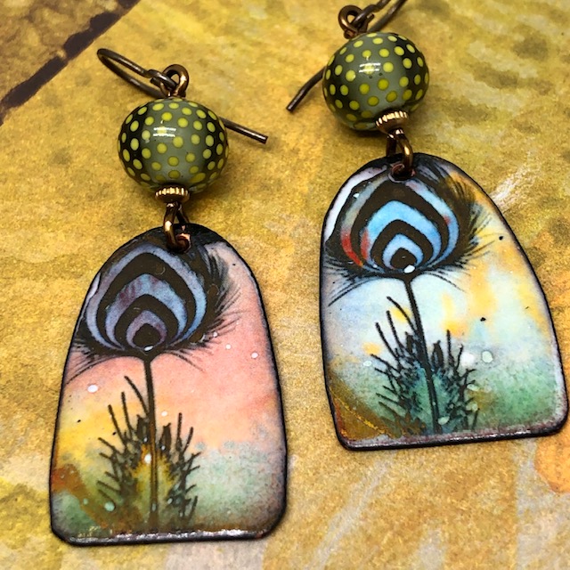 Boucles d'oreilles plumes de paon composées de pendentifs artisanaux en cuivre émaillé et de perles lampwork. Pièces uniques.