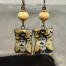 Boucles d’oreilles bohèmes asymétriques composées de pendentifs en céramique avec le portrait d'un homme entourée de papillons. Bijoux uniques.