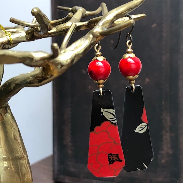 Boucles d'oreilles composées de pendentifs en métal et de perles en pierre howlite d'un rouge éclatant. Crochets d'oreilles en laiton. Pièces uniques.