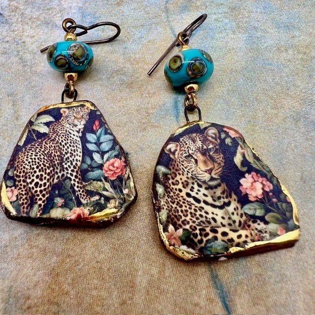 Boucles d’oreilles asymétriques composées de pendentifs en céramique avec un motif léopard et de perles en verre bleu turquoise et bronze. Bijoux uniques.