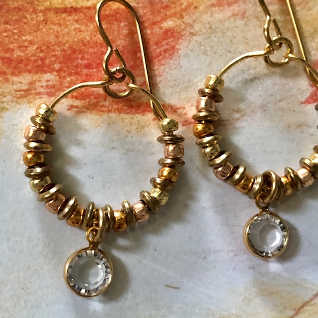 Créoles composées d'une breloque en cristal Swarovski, de perles de rocailles japonaises Toho et de perles en laiton. Crochets d'oreilles en métal.