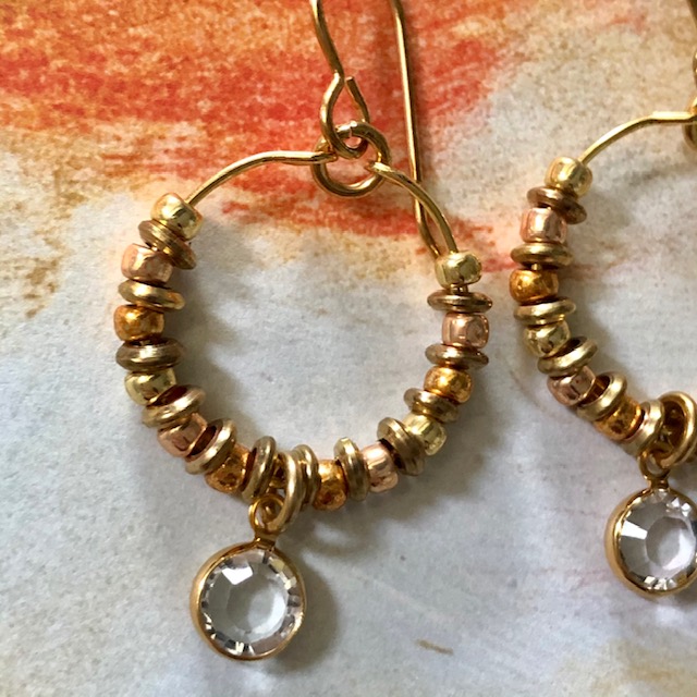 Créoles composées d'une breloque en cristal Swarovski, de perles de rocailles japonaises Toho et de perles en laiton. Crochets d'oreilles en métal.