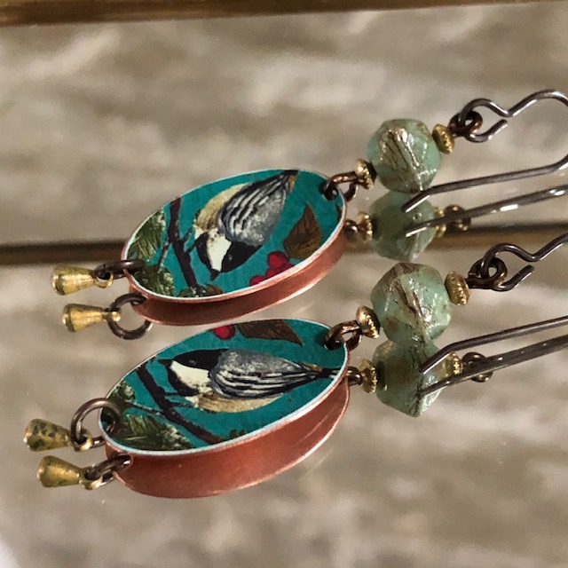 Boucles d'oreilles composées de pendentifs artisanaux en cuivre illustré et de perles en vert tchèque. Crochets d'oreilles en laiton. Pièces uniques.