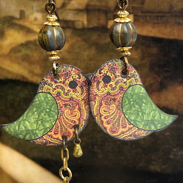 Boucles d'oreilles bohème en forme d'oiseau composées de pendentifs en cuivre émaillé couleur bois et kaki. Pièces uniques.