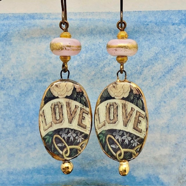 Boucles d'oreilles bohèmes composées de pendentifs en céramique avec le mot LOVE sur un fond floral et de perles lampwork. Bijoux uniques.