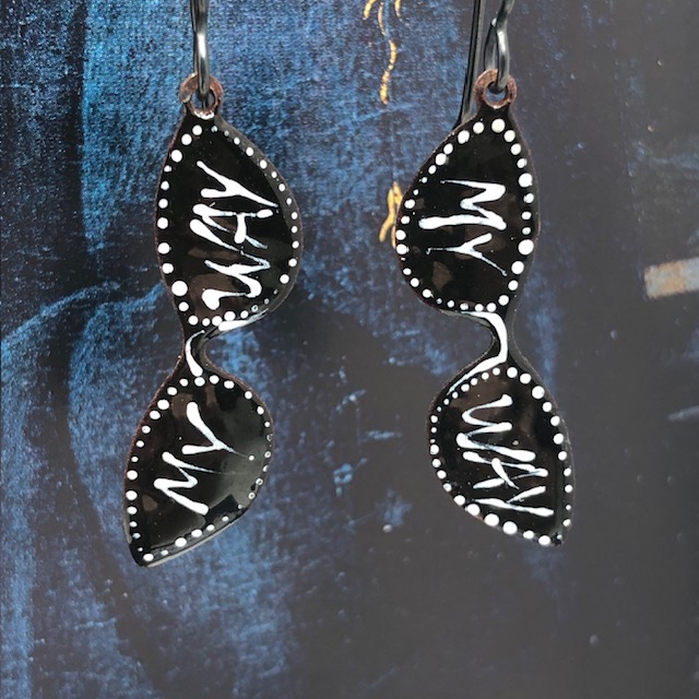 Petites boucles d'oreilles vintages composées de pendentifs artisanaux en cuivre émaillé qui représentent une paire de lunettes de soleil noire et blanche.