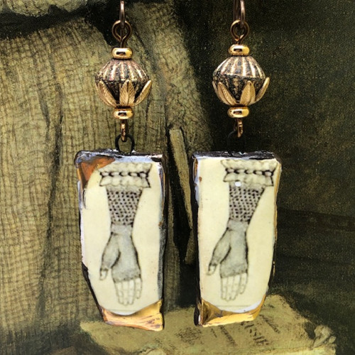 Boucles d’oreilles asymétriques composées de pendentifs en céramique représentant une main avec une mitaine en dentelle couleur sépia. Bijoux uniques.