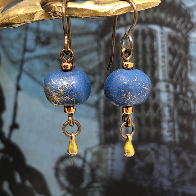 Petites boucles d'oreilles composées de perles rondes artisanales en argile polymère bleu nuit avec des paillettes or. Pièces uniques.