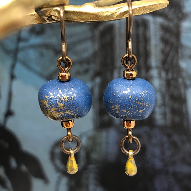 Petites boucles d'oreilles composées de perles rondes artisanales en argile polymère bleu nuit avec des paillettes or. Pièces uniques.