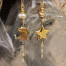 Longues boucles d'oreilles asymétriques Moon and Star composées de pendentifs en céramique dorée. Bijoux uniques de créateur.