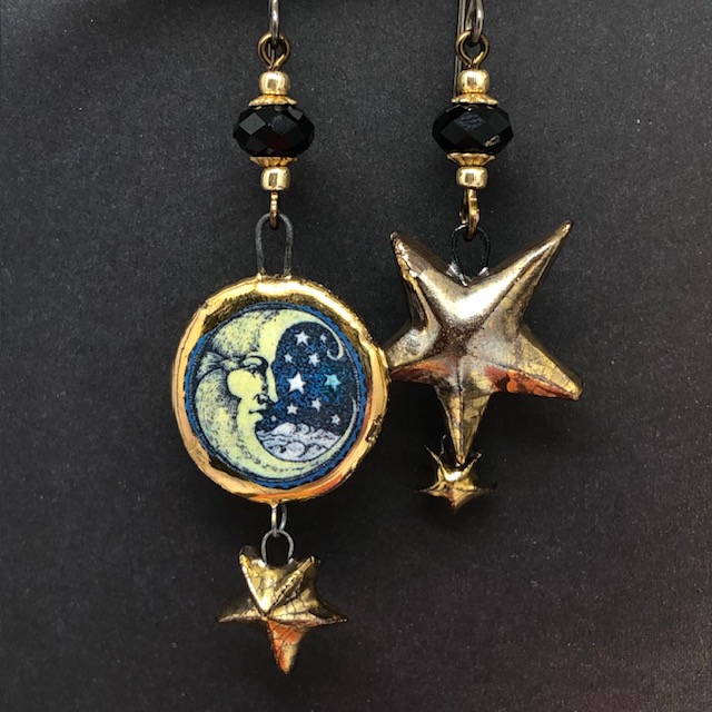 Boucles d'oreilles de créateur asymétriques composées de pendentifs en céramique en forme de lune et d'étoiles bronze doré. Bijoux uniques.