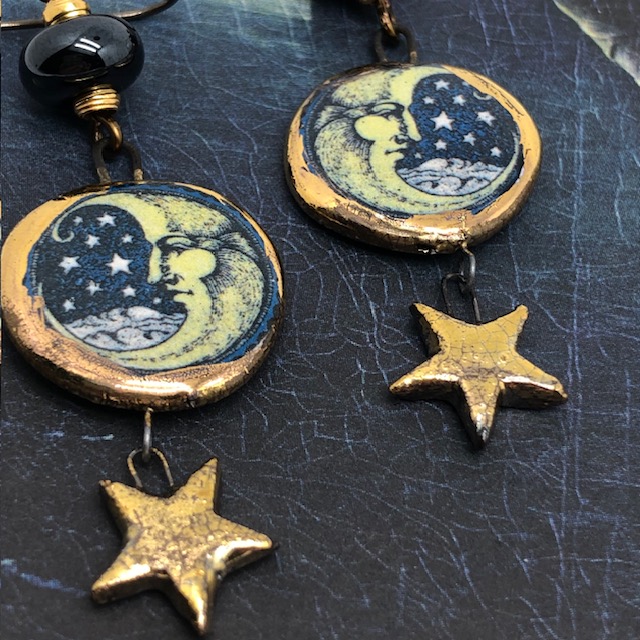 Boucles d'oreilles de créateur composées de pendentifs en céramique en forme de lune et de perles en verre filé à la flamme bleu nuit. Bijoux uniques.