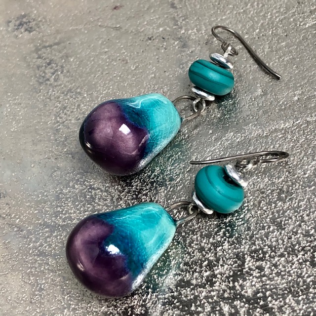 Boucles d'oreilles en forme de goutte composées de perles artisanales en céramique et en verre bleu lagon. Pièces uniques.