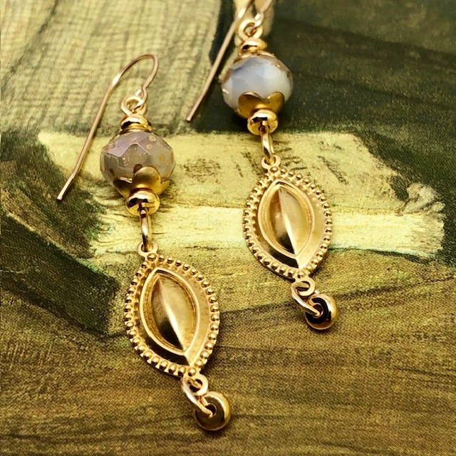 Boucles d’oreilles glamour composées de pendentifs en laiton doré en forme de navette et de perles en verre tchèque blanc et or.