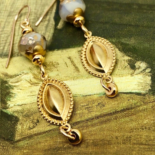 Boucles d’oreilles glamour composées de pendentifs en laiton doré en forme de navette et de perles en verre tchèque blanc et or.