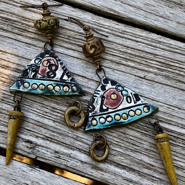 Boucles d'oreilles composées de pendentifs artisanaux en céramique, de perles en pâte polymère et de perles africaines en laiton. Pièces uniques.