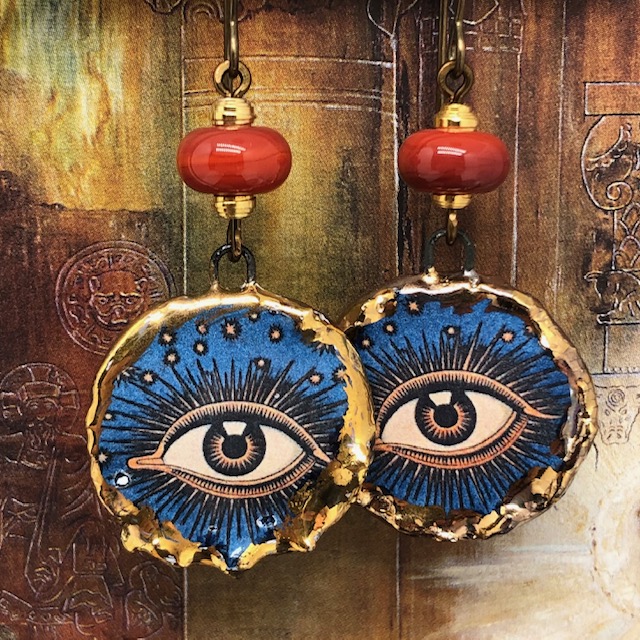 Boucles d'oreilles oeil protecteur composées de pendentifs en céramique bleus et de perles en verre filé. Bijoux uniques.