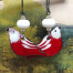 Boucles d'oreilles bohèmes composées de pendentifs en cuivre émaillé représentant un oiseau rouge aux ailes blanches. Modèle unique.