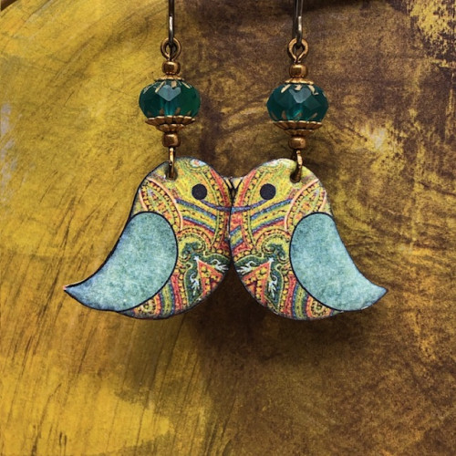 Boucles d’oreilles bohèmes composées de pendentifs en cuivre émaillé représentant un oiseau aux couleurs bigarrées. Bijoux uniques.