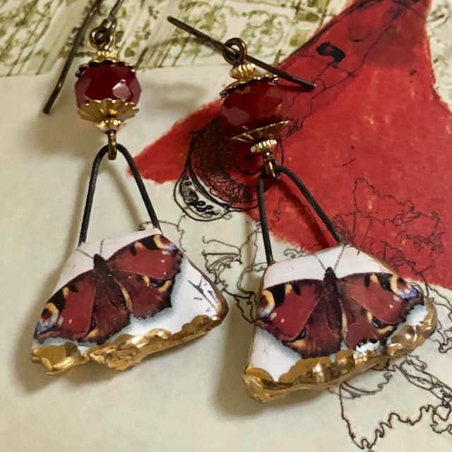 Boucles d'oreilles composées de pendentifs artisanaux en céramique et de perles rouge en verre tchèque. Crochets d'oreilles en laiton. Pièces uniques.