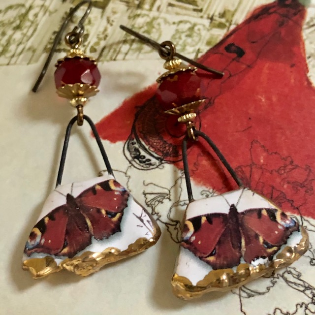 Boucles d'oreilles composées de pendentifs artisanaux en céramique et de perles rouge en verre tchèque. Crochets d'oreilles en laiton. Pièces uniques.