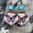 Boucles d'oreilles bohèmes composées de pendentifs en cuivre émaillé avec un papillon bleu et mauve. Bijoux uniques de créateur.