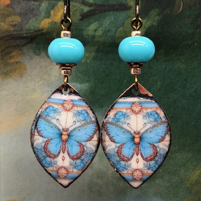 Boucles d'oreilles bohèmes composées de pendentifs en cuivre émaillé avec un papillon bleu turquoise et cuivre. Bijoux uniques de créateur.