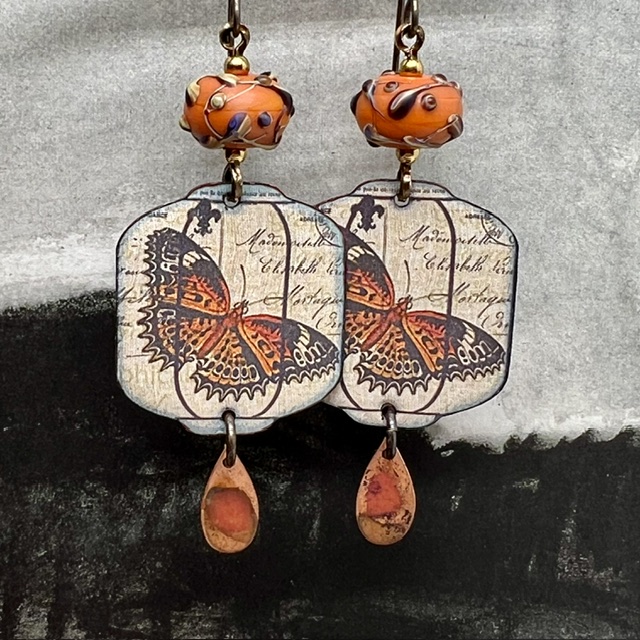 Grandes boucles d'oreilles uniques vintage composées de pendentifs en cuivre émaillé avec un papillon orange brûlé et de perles en verre filé à la flamme.