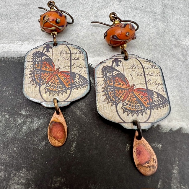 Grandes boucles d'oreilles uniques vintage composées de pendentifs en cuivre émaillé avec un papillon orange brûlé et de perles en verre filé à la flamme.