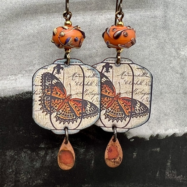 Grandes boucles d'oreilles uniques vintage composées de pendentifs en cuivre émaillé avec un papillon orange brûlé et de perles en verre filé à la flamme.