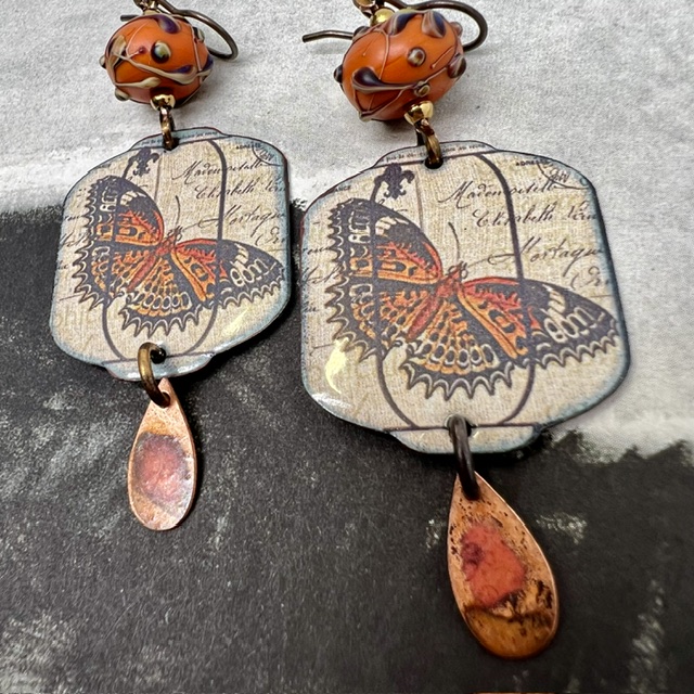 Grandes boucles d'oreilles uniques vintage composées de pendentifs en cuivre émaillé avec un papillon orange brûlé et de perles en verre filé à la flamme.