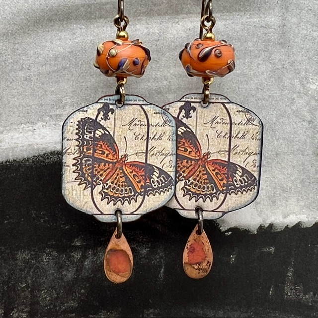 Grandes boucles d'oreilles uniques vintage composées de pendentifs en cuivre émaillé avec un papillon orange brûlé et de perles en verre filé à la flamme.