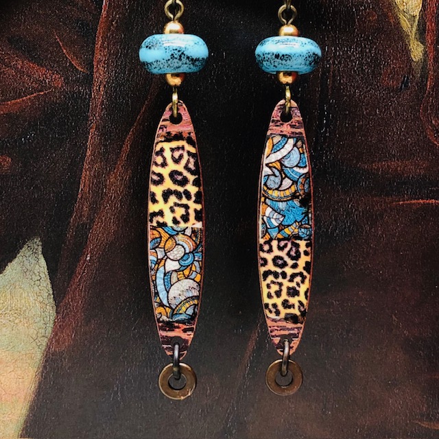 Longues boucles d’oreilles ethniques composées de pendentifs en laiton émaillé avec un motif ethnique bleu et un motif léopard. Bijoux uniques de créateur.