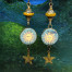 Longues boucles d’oreilles bohème chic composées de pendentifs en céramique représentant un soleil au visage énigmatique. Bijoux de créateur.