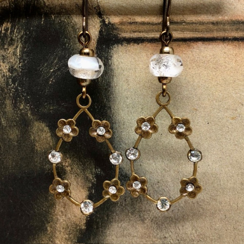 Boucles d'oreilles vintage composées de pendentifs en laiton doré ornées de petites fleurs serties de cristaux blancs. Bijoux uniques de créateur.